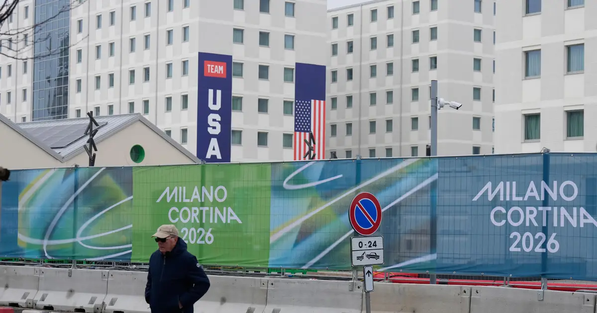 Athletes bring Milan Olympic Village to life , complete with Italian bidets and 4 - story US banners